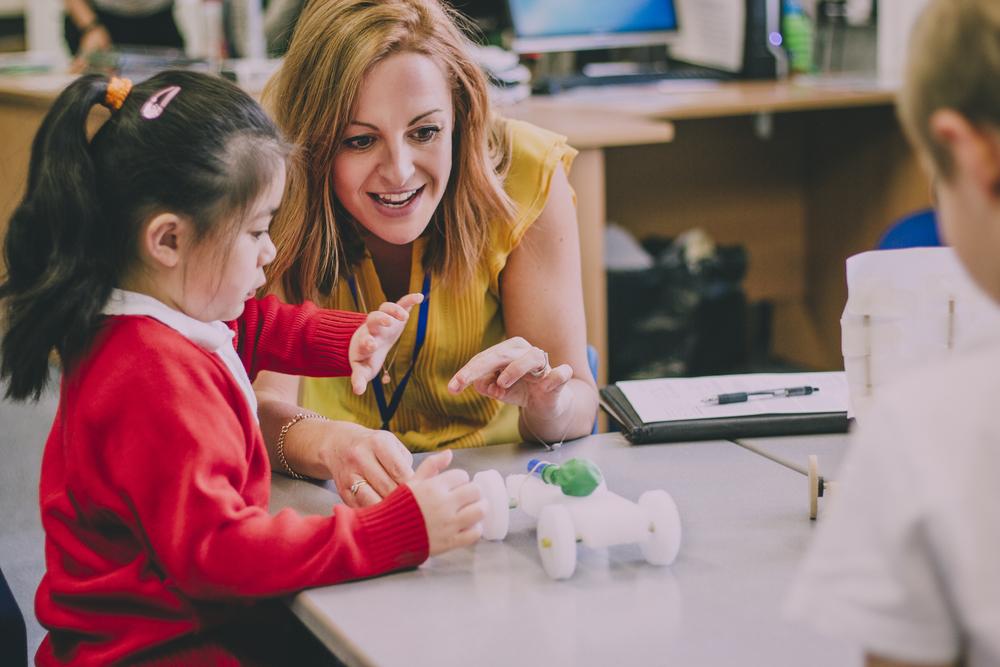 female teacher after receiving her degree to become a teacher with a young girl